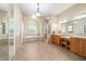 Spacious bathroom featuring tile flooring, tub with columns, glass shower, double vanity, and ample lighting at 2417 Se 23Rd St, Ocala, FL 34471