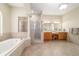 Bright bathroom featuring a separate shower and bathtub, tile flooring, double vanity, and decorative columns at 2417 Se 23Rd St, Ocala, FL 34471