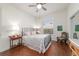 Cozy bedroom with hardwood floors, a ceiling fan, natural light and an ornamental iron bed frame at 2417 Se 23Rd St, Ocala, FL 34471