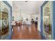 Inviting living room featuring hardwood floors, pendant lighting, and decorative glass paneled front doors at 2417 Se 23Rd St, Ocala, FL 34471