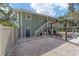 Two-story house with outdoor stairs, grill, hammock, and gravel yard at 24628 Fox Rd, Astor, FL 32102