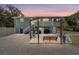 Inviting backyard with a swing set, outdoor seating, grill, and ample space for relaxation and entertainment at dusk at 24628 Fox Rd, Astor, FL 32102