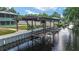 Waterfront covered dock and boat lift on a sunny day at 24628 Fox Rd, Astor, FL 32102
