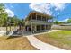 Back exterior view of a home featuring a patio with seating, grill and staircase at 24628 Fox Rd, Astor, FL 32102