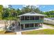 Exterior view of a two-story home with a screened-in porch and outdoor seating area at 24628 Fox Rd, Astor, FL 32102