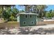 Two-story home with a metal roof and fenced gravel yard at 24628 Fox Rd, Astor, FL 32102