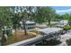 A back exterior view shows the home, dock, boat cover, and screened-in porch at 24628 Fox Rd, Astor, FL 32102