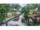 Exterior view of a canal-front home with a covered boat lift, dock, and lush landscaping at 24628 Fox Rd, Astor, FL 32102
