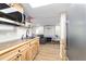 View of a kitchenette with wood cabinets, stainless appliances, and an opening into the living and game room at 24628 Fox Rd, Astor, FL 32102