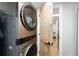 View of the laundry room with a stacked washer/dryer and wood door leading to another area of the house at 24628 Fox Rd, Astor, FL 32102