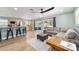 Stylish open-concept living room, featuring barstool seating, and a comfortable seating area with hardwood floors at 24628 Fox Rd, Astor, FL 32102