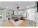 Bright living room with a comfortable sectional sofa, wood-look floors, and natural light from sliding glass doors at 24628 Fox Rd, Astor, FL 32102