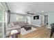 Bright living room with a comfortable sectional sofa, wood-look floors, and natural light from sliding glass doors at 24628 Fox Rd, Astor, FL 32102