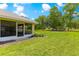 Beautifully landscaped backyard with lush green grass and access from a sunroom, ideal for outdoor living at 28 Golf View Dr, Ocala, FL 34472