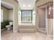 Updated bathroom with shower, tub, and neutral green wallpaper at 28 Golf View Dr, Ocala, FL 34472