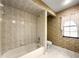 Bathroom with bathtub and shower with beige tiling and patterns at 28 Golf View Dr, Ocala, FL 34472