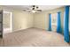 Bedroom with neutral carpet, ceiling fan and blue curtains at 28 Golf View Dr, Ocala, FL 34472