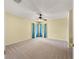 Bedroom with neutral carpet, ceiling fan and blue curtains at 28 Golf View Dr, Ocala, FL 34472