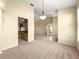 Open-concept living room with neutral carpet, modern lighting fixtures, and seamless flow into the adjacent kitchen at 28 Golf View Dr, Ocala, FL 34472