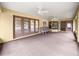 Carpeted sunroom with a ceiling fan, multiple seating options, and access to the backyard at 28 Golf View Dr, Ocala, FL 34472