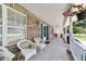 Relaxing front porch with white wicker furniture, decorative pillows, and charming details at 2820 Se 14Th St, Ocala, FL 34471