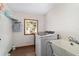 Functional laundry room with a modern washer, utility sink, and storage shelves for an organized space at 2820 Se 14Th St, Ocala, FL 34471