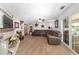 Open-concept living room with a fireplace, brown leather seating, and abundant natural light at 2820 Se 14Th St, Ocala, FL 34471