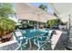 Enjoy outdoor dining under a large umbrella on the beautiful blue patio furniture by the pool at 2820 Se 14Th St, Ocala, FL 34471