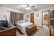 Bright bedroom featuring a ceiling fan, neutral carpet, and a wooden accent chest at the foot of the bed at 2981 Ne 39Th Pl, Ocala, FL 34479