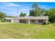 Beautiful brick single-story home with a metal roof, green lawn, and charming curb appeal at 2981 Ne 39Th Pl, Ocala, FL 34479