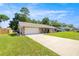 Charming single-story brick home with a metal roof, lush green lawn, and attached garage at 2981 Ne 39Th Pl, Ocala, FL 34479