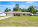 Charming single-story home features a brick facade, metal roof, and attached garage on a well-maintained lawn at 2981 Ne 39Th Pl, Ocala, FL 34479