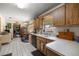 Sunlit kitchen boasts wood cabinets, white tile floors, and an adjacent breakfast nook at 2981 Ne 39Th Pl, Ocala, FL 34479