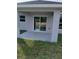 A cozy rear patio with gray flooring transitions from the sliding glass door to the lawn at 3079 Sw 168 Loop, Ocala, FL 34473
