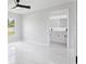 Bright bedroom with large window and bathroom entrance, featuring modern marble floors at 3079 Sw 168 Pl, Ocala, FL 34473