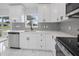 A modern kitchen features white cabinets, marble floors, stainless appliances, and backsplash at 3079 Sw 168 Pl, Ocala, FL 34473