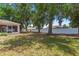 Large backyard with mature trees, a white fence, and ample space for outdoor activities and landscaping at 3102 Ne 26Th St, Ocala, FL 34470