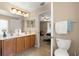 Bright Primary bathroom with double sinks, wood cabinets, and a private toilet room at 3102 Ne 26Th St, Ocala, FL 34470
