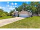 Exterior view of the house, highlighting the lush green lawn and curb appeal with mature landscaping at 3102 Ne 26Th St, Ocala, FL 34470