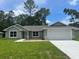 Charming single-story home featuring a well-manicured lawn and attached two-car garage at 4105 Se 138Th Pl, Summerfield, FL 34491