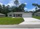Charming single-story home featuring a well-manicured lawn and attached two-car garage at 4105 Se 138Th Pl, Summerfield, FL 34491