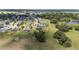 Aerial view displays a neighborhood with lush lawns, serene pond, and inviting homes with screened pools at 4360 Sw 62Nd Loop, Ocala, FL 34474