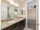 Bathroom with double sink vanity, granite countertop, dark cabinets, and walk-in shower with white tile at 4360 Sw 62Nd Loop, Ocala, FL 34474