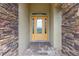 Stylish front door framed by stone pillars, with a patterned glass window and stone walkway at 4360 Sw 62Nd Loop, Ocala, FL 34474