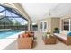 Comfortable covered patio featuring wicker furniture, a glass coffee table, and views of the pool area at 4360 Sw 62Nd Loop, Ocala, FL 34474