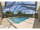 Screened-in swimming pool with a jacuzzi, surrounded by lush landscaping for privacy, all under a bright blue sky at 4360 Sw 62Nd Loop, Ocala, FL 34474
