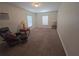 Cozy bedroom features soft carpet, bright windows, and comfortable seating area for relaxation at 5130 Se 106 Lane, Belleview, FL 34420