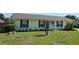 Charming single-story home features a well-manicured lawn and a welcoming entrance with black shutters and a cheerful wreath at 5130 Se 106 Lane, Belleview, FL 34420