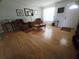 Inviting living room with wood floors, neutral walls, comfortable seating, and abundant natural light from the front door at 5130 Se 106 Lane, Belleview, FL 34420