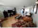 Open-concept living room featuring wood-look floors, neutral paint, and views of the dining and kitchen areas at 5130 Se 106 Lane, Belleview, FL 34420